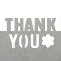 Le texte "Thank you", avec une découpe en forme de fleur pour le O, est réalisé en papier gris texturé à l'aide de la perforatrice Artoz Papier AG Bordüre Stanzer "Thank you" L, sur fond blanc.