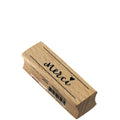 L'Artoz Papier AG Stempel Merci est un tampon en caoutchouc rectangulaire portant l'inscription "merci" et un cœur en cursive noire. Idéal pour les travaux manuels, il est doté d'une base en bois et d'un code-barres autocollant sur une face.