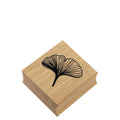 Der Stempel Ginkgo von Artoz Papier AG zeigt ein schwarz umrandetes Ginkgoblatt auf einem Holzblock, ideal für Bastelarbeiten oder zur Personalisierung von Einladungskarten, abgebildet auf einem weißen Hintergrund.