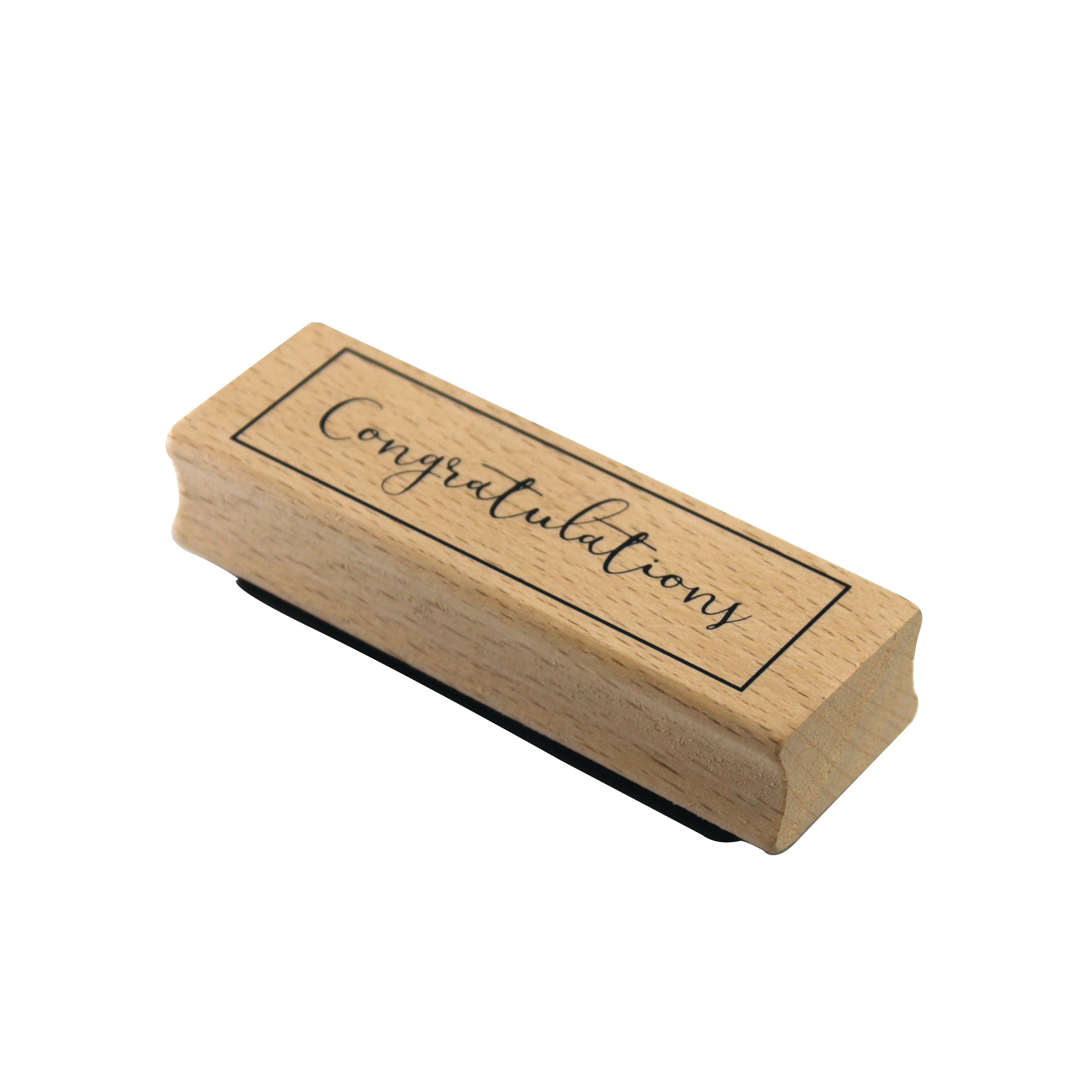 Der Stempel Congratulations von Artoz Papier AG ist ein Holzstempel mit dem kursiven Schriftzug "Congratulations" in einem rechteckigen Rahmen, ideal für Bastelarbeiten.