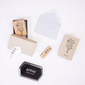 Une mise en page plate présente le Stempel Blume d'Artoz Papier AG, un tampon encreur à pigments, une étiquette vierge, une enveloppe et une carte fleurie POUR VOUS - idéale pour les Bastelarbeiten ou les Einladungskarten - sur un fond blanc.