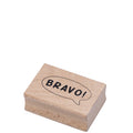 Der Stempel Bravo! von Artoz Papier AG ist ein kleiner rechteckiger Holzstempel, der ein fettes schwarzes "BRAVO!" in einer Sprechblase zeigt - perfekt für Bastelarbeiten oder als Holzstempel Bravo auf Einladungskarten. Einfarbig weißer Hintergrund.