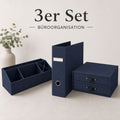 Dreiteiliges Büro-Organisationsset von Artoz Papier AG in Dunkelblau (3er-Set Büro-Organisation blau), bestehend aus einem Schreibtisch-Organizer, einer Aufbewahrungsbox mit Schubladen und einem Aktenordner – ideal für die Organisation im Homeoffice oder im Büro. Im Hintergrund sorgt eine Vase mit grünem Laub für eine elegante Note. Der Text lautet: „3er Set Büroorganisation“.