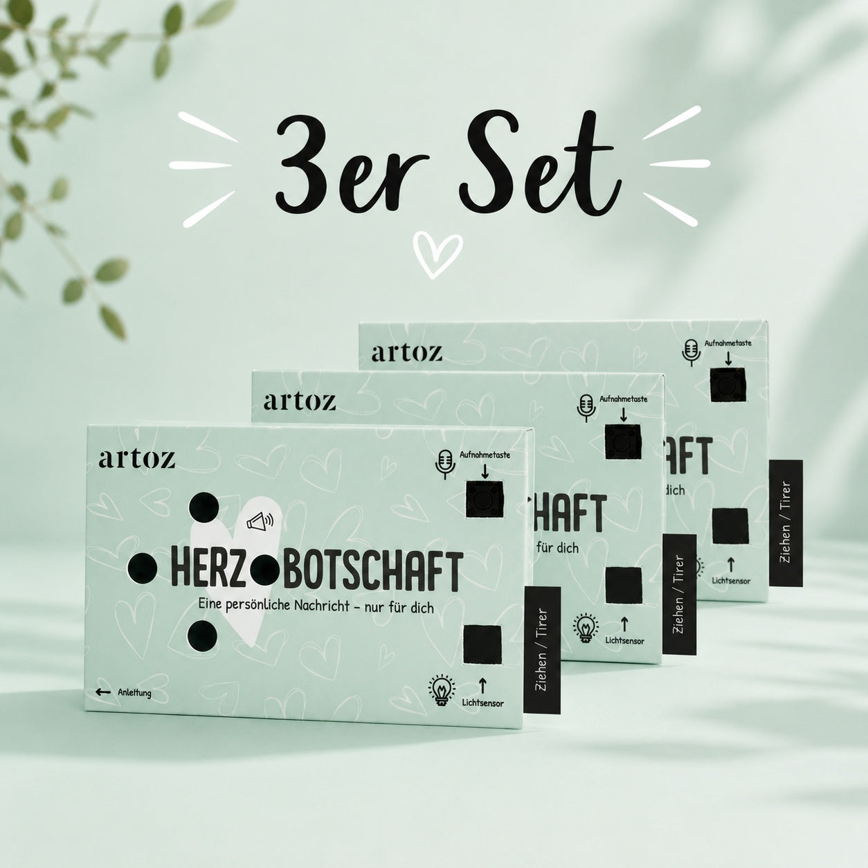 Drei pastellgrüne „3er-Set Ton-Box Herzbotschaft“-Kartensets von Artoz Papier AG sind in einer Reihe auf einem hellgrünen Hintergrund angeordnet, darüber sind die Aufschrift „3er-Set“ und eine Herzgrafik zu sehen. Die Verpackung ist mit schwarzem Text und kleinen Symbolen versehen, was dieses Set zu einem idealen Sprachaufnahme-Geschenk macht, das sich für eine besonders persönliche Note mit einem Soundmodul mit Lichtsensor kombinieren lässt.