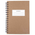 Notizbuch A5 à couverture rigide et à spirale de couleur marron, avec des pages lignées, fabriqué par Artoz Papier AG. L'étiquette blanche de la couverture affiche "NOTEBOOK" et comprend deux lignes vierges pour des notes personnelles.