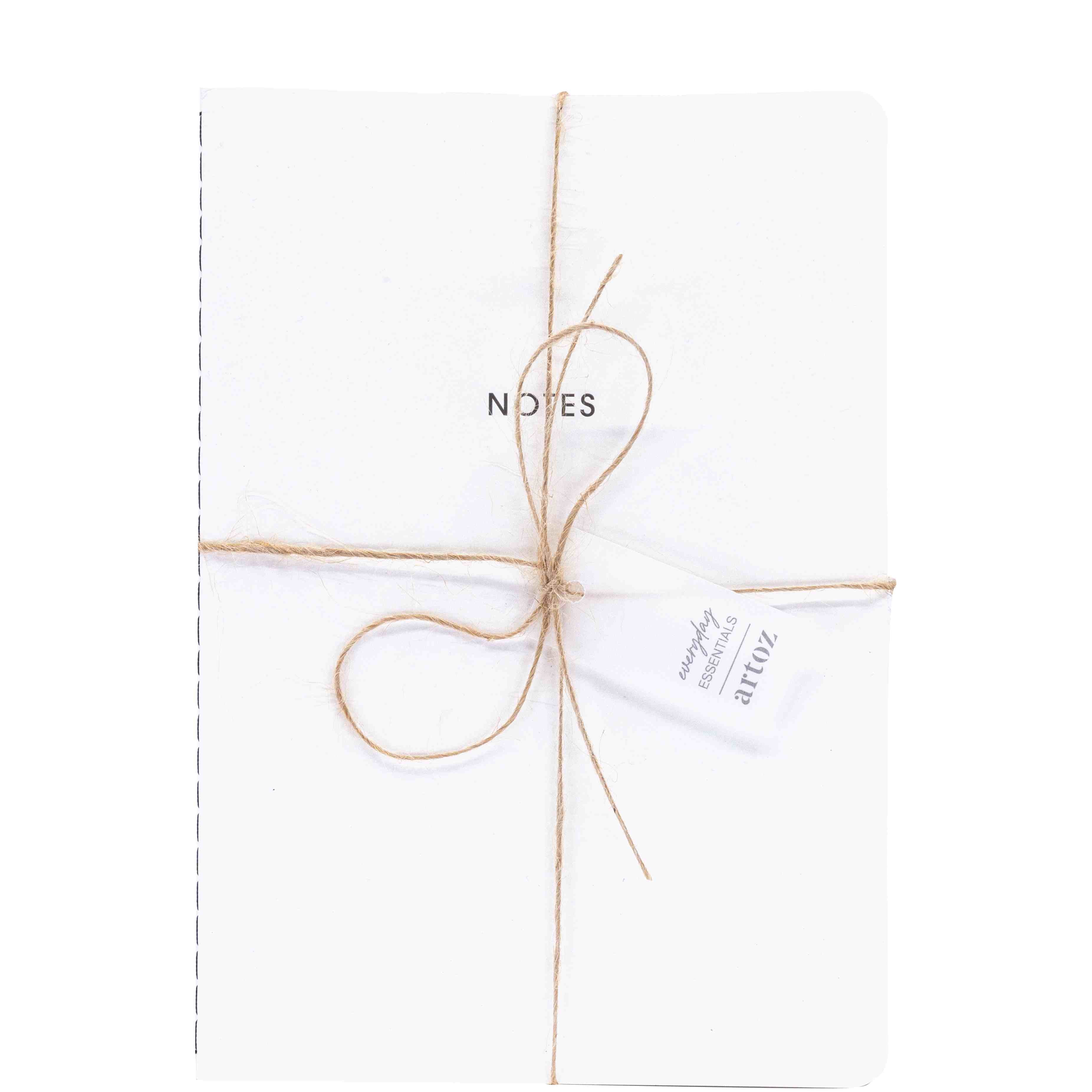 Un Notizheft A5 blanc d'Artoz Papier AG, avec la mention NOTES sur la couverture, attaché avec de la ficelle marron et une étiquette "atticz". Idéal pour un set élégant de 40 Blatt A5 Notizheft.