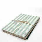 Le A5 Notizheft 3er Set farbig d'Artoz Papier AG comprend trois carnets A5 à pois avec des couvertures rayées vertes et blanches, attachées avec de la ficelle marron. Chaque carnet est fabriqué sur un papier de qualité supérieure de 80 g/m² et se détache sur un fond blanc uni.