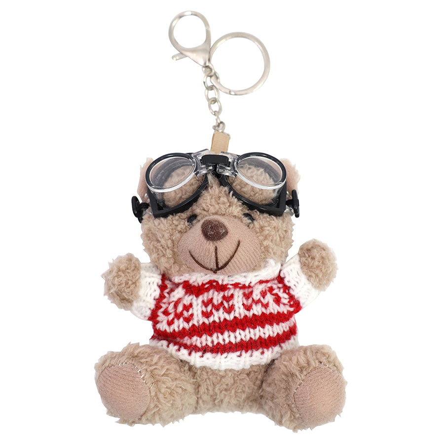 Le porte-clés « Teddy » – ours en peluche avec lunettes de ski, créé par Artoz Papier AG, représente un adorable ours en peluche portant des lunettes de ski noires et un pull en tricot rouge et blanc bien douillet, assis, les bras levés. Il constitue ainsi un cadeau d'hiver idéal sous la forme d'un charmant porte-clés.