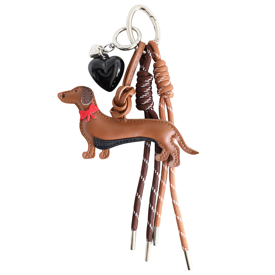 Bien sûr ! Voici la phrase reformulée en utilisant les données de votre produit : Le pendentif « Chien » en PU aspect cuir d’Artoz Papier AG se compose d’un pendentif en forme de teckel marron aspect cuir, fabriqué en PU de haute qualité, d’un cœur noir ainsi que de plusieurs cordons marron et beiges avec des embouts métalliques – le tout fixé à un anneau porte-clés argenté – ce qui en fait l'idée cadeau parfaite pour tous les amoureux des chiens.