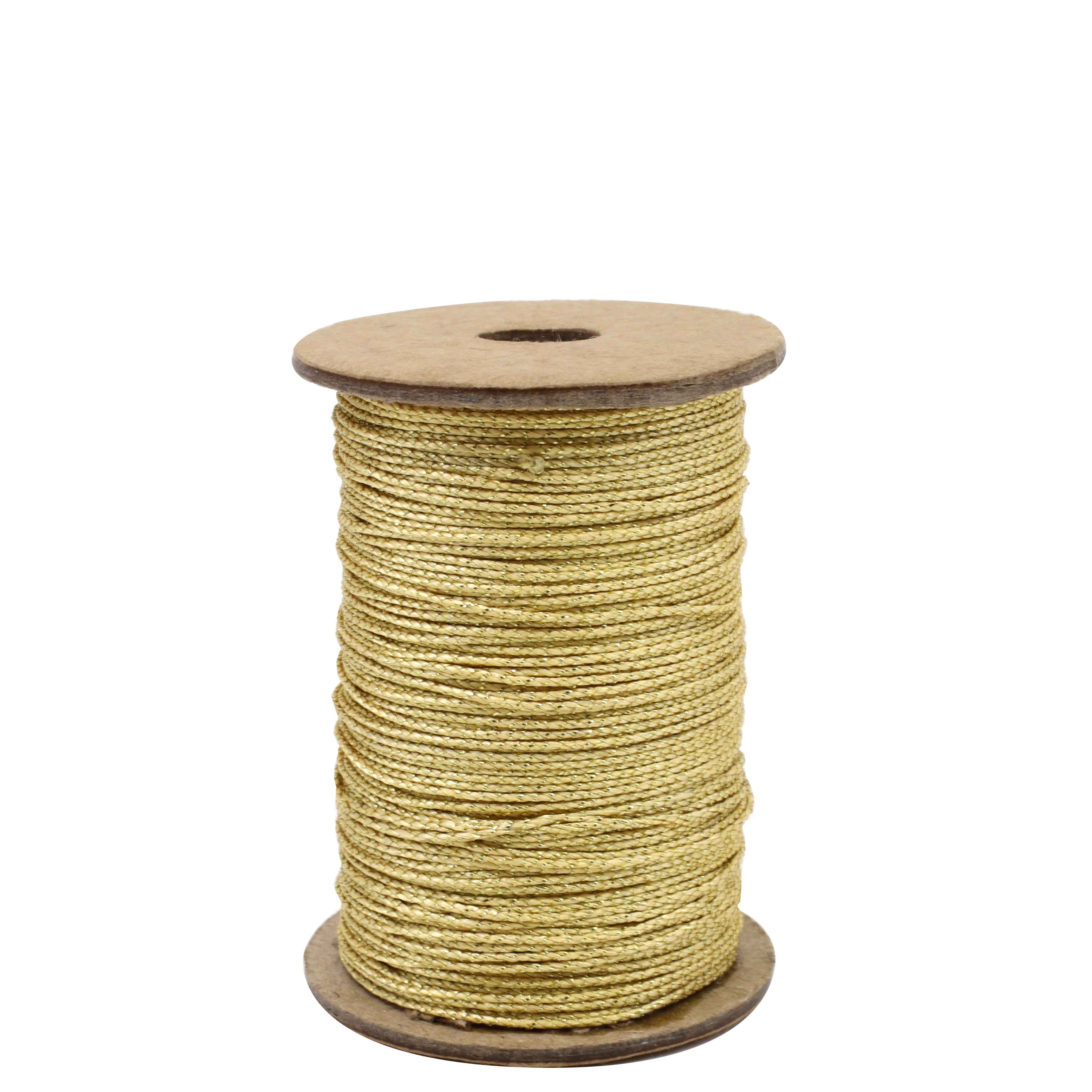 Eine Spule von Artoz Papier AG Geschenkband Gold lurex, ein geflochtenes goldfarbenes Metallgarn, das auf eine zylindrische Spule aufgewickelt ist, steht aufrecht vor einem weißen Hintergrund.