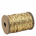 Das Geschenkband Tannenbaum Gold der Artoz Papier AG ist ein goldenes Dekoband mit Zickzack-Muster aus strapazierfähigem Polyester, das auf einer Kartonspule aufgewickelt ist und sich auf weißem Hintergrund präsentiert.