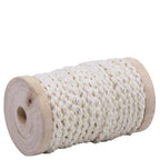 Eine Spule Geschenkband Weiss/Gold von Artoz Papier AG mit dickem, weiss-goldenem, geflochtenem Band mit dezentem Glanz, hergestellt aus strapazierfähigem Material und aufgewickelt auf eine zylindrische Holzspule mit zentralem Loch.