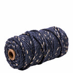 Une bobine de Artoz Papier AG Geschenkband Midnight blue - Gold, avec un ruban épais bleu foncé avec des accents dorés, étroitement enroulé autour d'une âme en carton et présenté sur un fond blanc.