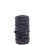 La bobine de Artoz Papier AG Geschenkband Midnight blue - Gold, aux accents bleu foncé et or, est soigneusement enroulée dans un cylindre et se tient droite sur un fond blanc. Ce ruban de 25 m est à la fois durable et élégant.