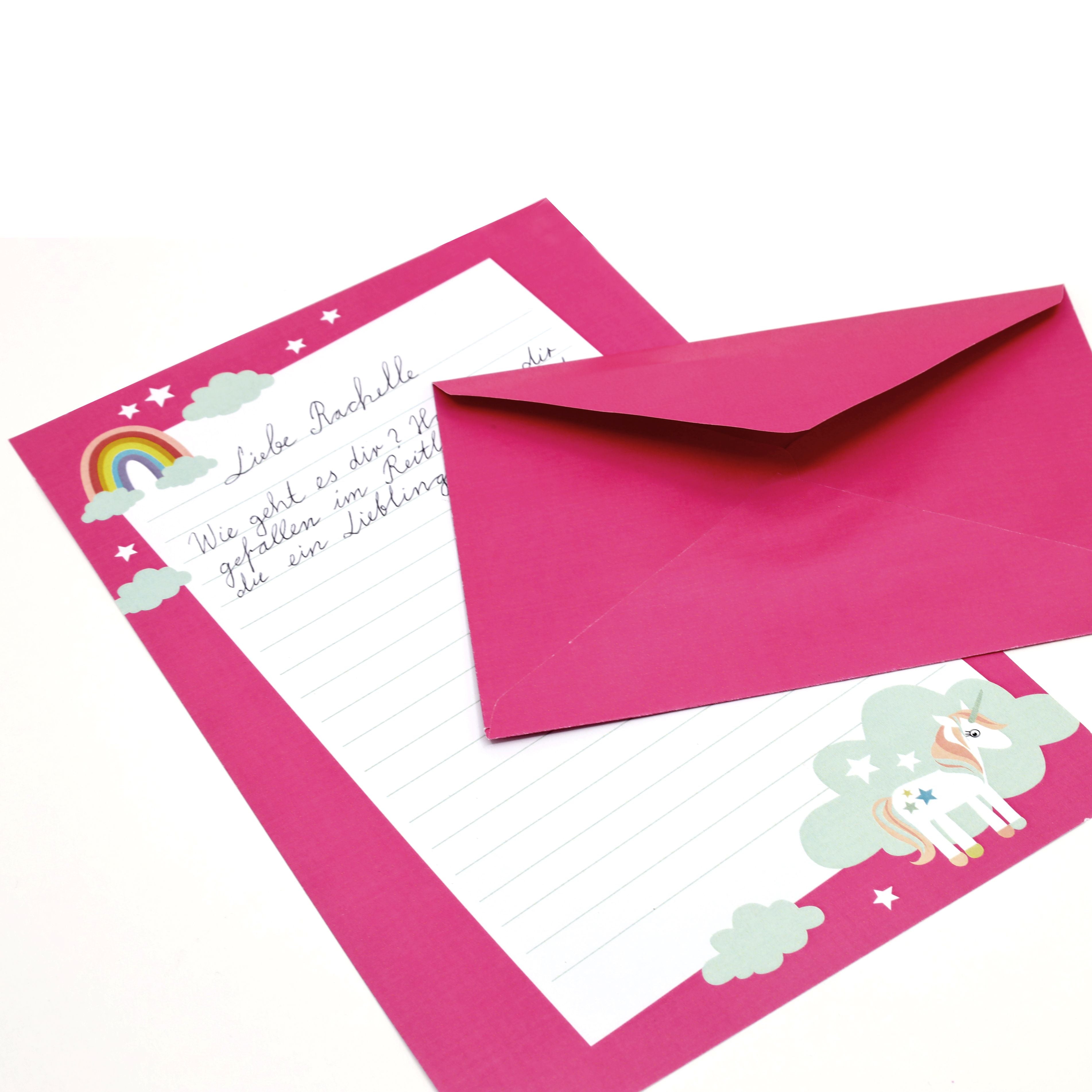 Le coffret d'écriture pour enfants « Einhorn » d'Artoz Papier AG comprend une enveloppe rose et du papier à lettres assorti, décorés d'une licorne, d'un arc-en-ciel et de nuages. Le message manuscrit en allemand est partiellement recouvert par l'enveloppe.