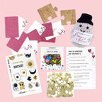 Das "Inhaltset für Tischbombe - Thema Liebe" der Artoz Papier AG enthält Puzzleteile, Spielkarten, eine gehäkelte Puppe, goldenes Konfetti, Tattoos und illustrierte deutsche Karten - ideal für eine DIY-Tischbombe zum Thema Liebe.
