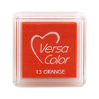 Un Ministempelkissen VersaColor orange carré d'Artoz Papier AG dans un étui transparent avec un motif en forme de cœur, parfait pour combiner avec d'autres teintes VersaColor ou Stempelfarbe.