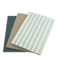 Trois Notizhefte A5 d'Artoz Papier AG sont empilées et légèrement disposées en éventail : ce 3er Set farbig présente un papier de 80g/m² avec une couverture verte, une couverture marron uni et une couverture rayée vert clair et blanc.