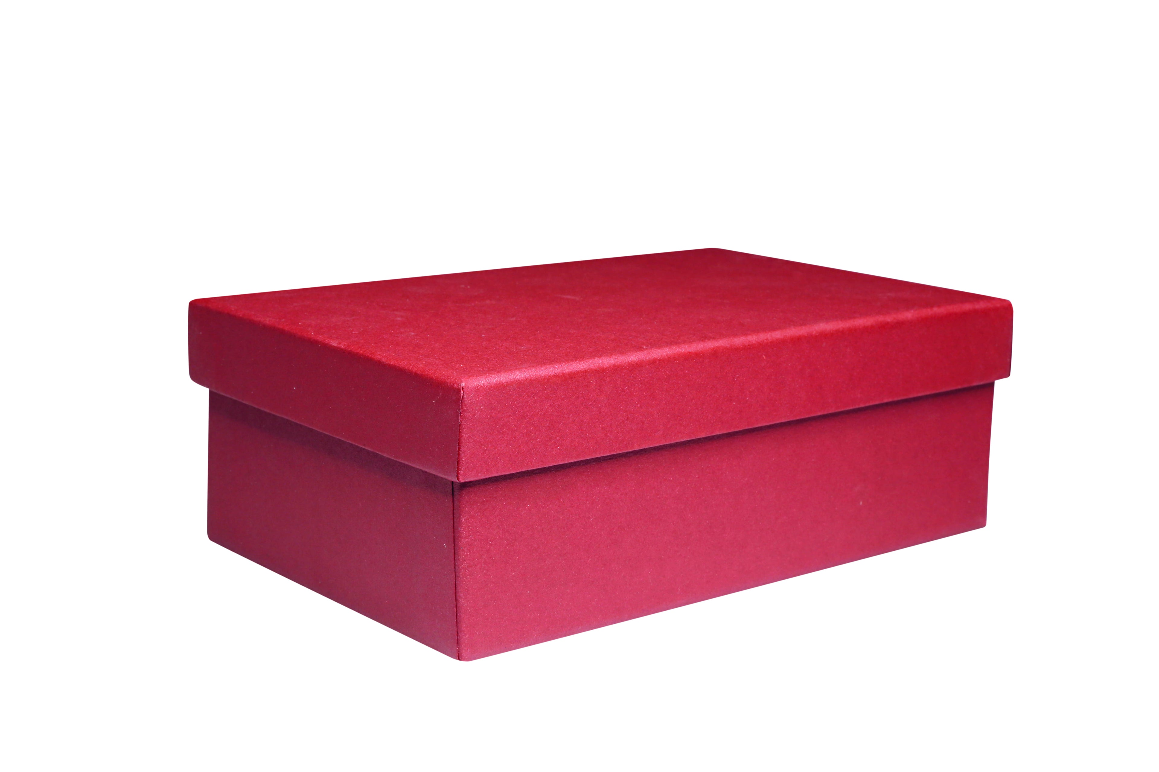 Une « Geschenk-Box Pure M » rouge, rectangulaire et fermée, fabriquée par Artoz Papier AG, dotée d'un couvercle ajusté et d'une structure solide en carton livre, sert d'élégant emballage cadeau et est présentée sur un fond blanc.