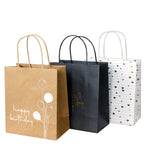 Le set Artoz Papier AG Geschenktaschen Happy Birthday (317) comprend trois sacs verticaux : marron avec des motifs d'anniversaire et de ballon, noir avec des écritures dorées et blanc avec des cœurs/lignes dorés. Tous les sacs sont munis d'une poignée torsadée.