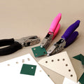 Trois perforatrices Artoz Papier AG Handlocher Kreis avec des poignées noires, roses et violettes découpent des étoiles, des cœurs et des cercles dans du papier vert ou beige. Elles sont idéales pour ajouter des détails créatifs à tout projet d'artisanat Basteln.