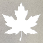 La silhouette blanche d'un Ahornblatt est centrée sur un fond texturé gris clair. Idéal pour les Basteln ou pour l'utilisation de l'Artoz Papier AG Stanzer M Ahornblatt.