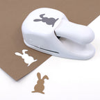 Artoz Papier AG Stanzer M Osterhase découpe des silhouettes de lapins dans du Bastelpapier Osterdeko brun, créant ainsi des découpes de lapins blancs et bruns, idéales pour les Karten basteln Ostern.