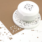 Un Fliegender Stanzer Sterne d'Artoz Papier AG est présenté sur une feuille brune, avec des confettis en forme d'étoiles - idéal pour les Basteln ou pour rehausser les Karten avec des motifs créatifs de bordures comportant des étoiles poinçonnées.