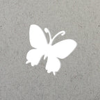 La silhouette blanche d'un papillon, comme celle du Stanzer S Schmetterling d'Artoz Papier AG, est centrée sur un fond gris clair texturé, idéal pour les projets Bastelzubehör ou Karten gestalten.