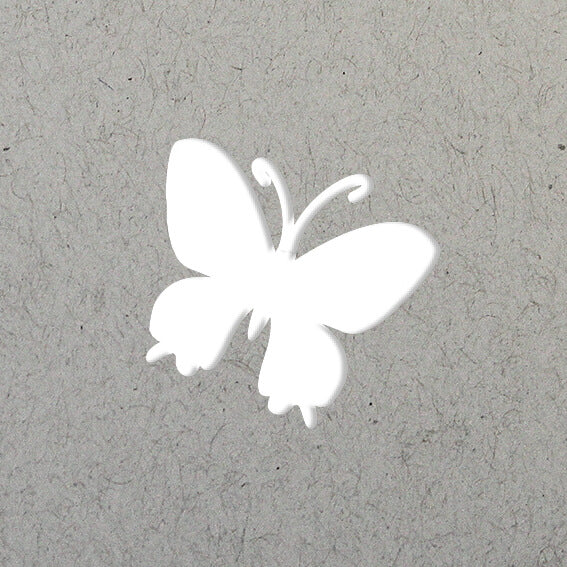 La silhouette blanche d'un papillon, comme celle du Stanzer S Schmetterling d'Artoz Papier AG, est centrée sur un fond gris clair texturé, idéal pour les projets Bastelzubehör ou Karten gestalten.