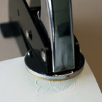 Eine Nahaufnahme eines Prägestempels der Artoz Papier AG (Ersatzmotiv „Engel“), der ein erhabenes Engelsmotiv auf ein Blatt weißes Papier prägt. Das unter dem Stempel teilweise sichtbare geprägte Motiv unterstreicht dessen Eignung für DIY-Projekte und filigrane dekorative Veredelungen.
