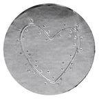 Une feuille d'argent ronde ornée d'un motif de cœur en relief au centre, réalisée à l'aide du tampon à gaufrer « Motiv Herz » d'Artoz Papier AG et rehaussée de délicats points en relief — idéale pour les projets de loisirs créatifs et pour apporter une touche de charme grâce à ce tampon à gaufrer.