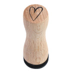 L'Artoz Papier AG Stempel Herz est un tampon en bois avec un simple motif de cœur noir sur le dessus, idéal pour Bastelarbeiten ou pour ajouter du charme aux Einladungskarten, montré d'en haut sur un fond blanc.