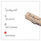 Le tampon « Stempel Winterzauber » d'Artoz Papier AG présente des motifs d'étoiles et un discret motif de sapin, réalisés à partir de bois de hêtre certifié FSC®. Mesurant 60 x 20 mm, ce tampon de conception suisse est idéal pour le scrapbooking ou pour apporter une touche festive. Le produit est partiellement visible sur fond blanc et comporte les icônes de certification correspondantes.