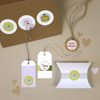 Eine Auswahl von Artoz Sticker für DICH von Artoz Papier AG auf beigem Hintergrund, mit pastellfarbenen Geschenkanhängern mit Tiermotiven und Sprüchen wie für DICH und HAPPY BIRTHDAY - einige mit Schnur gebunden, einer auf einer weißen Geschenkbox.