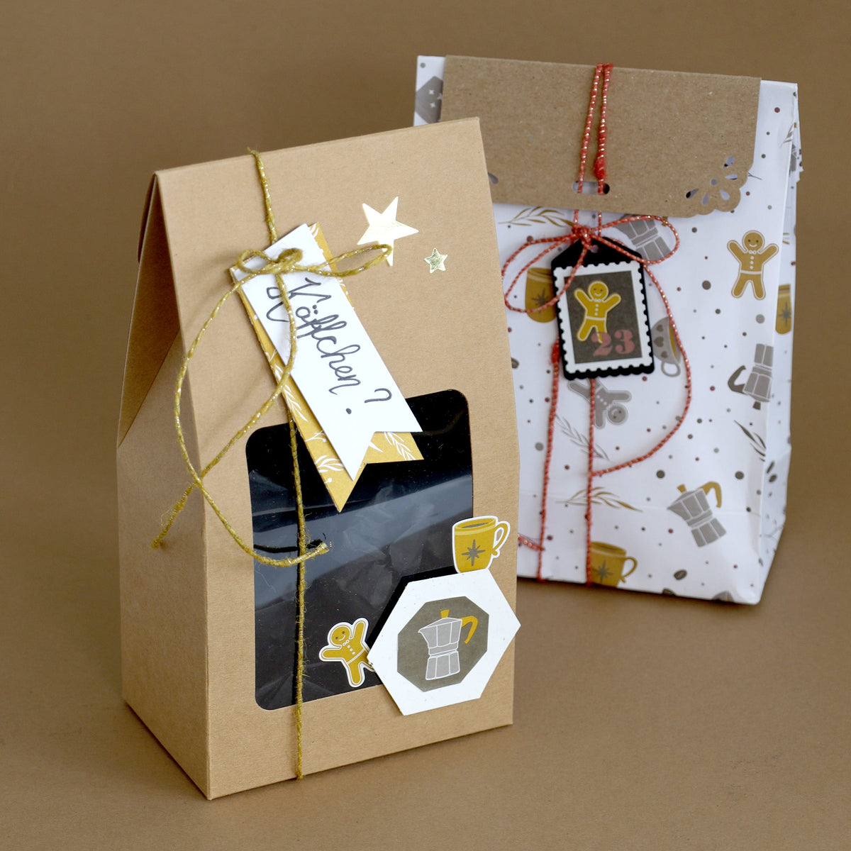 Deux sacs-cadeaux : l'un marron, muni d'un cordon et d'une étiquette sur le thème du café, et l'autre blanc, orné de motifs décoratifs, d'un cordon rouge et d'un autocollant « Tee-Kaffeetassen » de la marque Artoz Papier AG — une décoration DIY idéale pour embellir vos cadeaux —, tous deux présentés sur un fond marron.