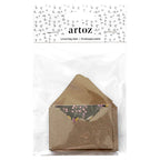 Eine Packung „Artoz Papier AG Geschenkkuvert klein“ – kleine braune Kraftpapier-Umschläge, ideal als Geschenkumschläge oder zur Verpackung von Gutscheinen, jeweils mit einer Karte mit Blumenmotiv. Das Set ist ansprechend in durchsichtiger Folie verpackt und trägt oben ein Artoz-Etikett sowie einen dekorativen Hintergrund im Schweizer Design.