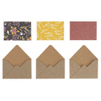 Drei braune Umschläge – das Modell „Geschenkkuvert klein“ von Artoz Papier AG – sind jeweils mit einer der oben abgebildeten Dekokarten kombiniert: eine mit Blumenmuster, eine weitere mit gelben und weißen Blättern verziert und die dritte mit goldenen Punkten auf rötlichem Hintergrund. Alle sind elegant auf einer weißen Fläche angeordnet und verkörpern raffiniertes Schweizer Design – ideal als Gutscheinverpackung für besondere Anlässe.