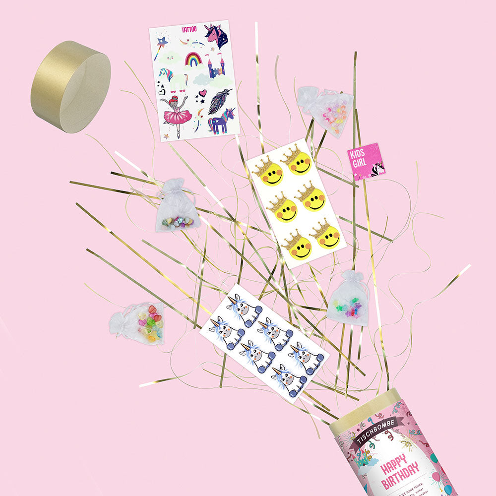 Une explosion de la Tischbombe ohne Feuer d'Artoz Papier AG - Happy Birthday Girl révèle des autocollants de licorne, de soleil et de zèbre, des sacs en filet avec des perles colorées et une étiquette "Kids Girl" sur un fond rose.